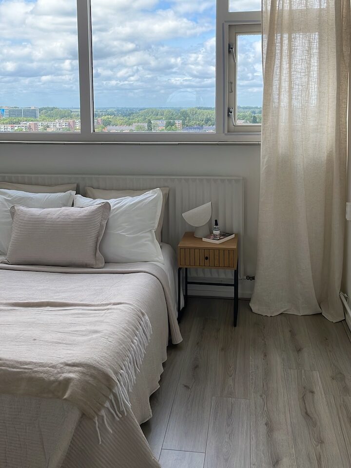 Woningstyling slaapkamer met neutrale kleuren en uitzicht