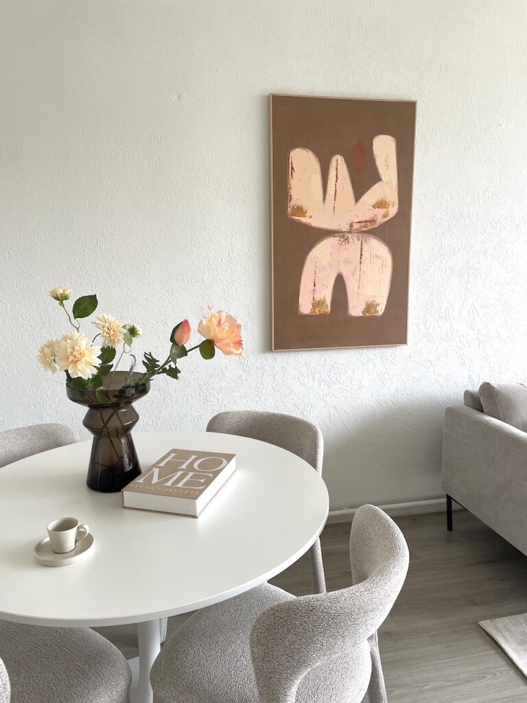 Gestylde eethoek met bloemen en wanddecoratie