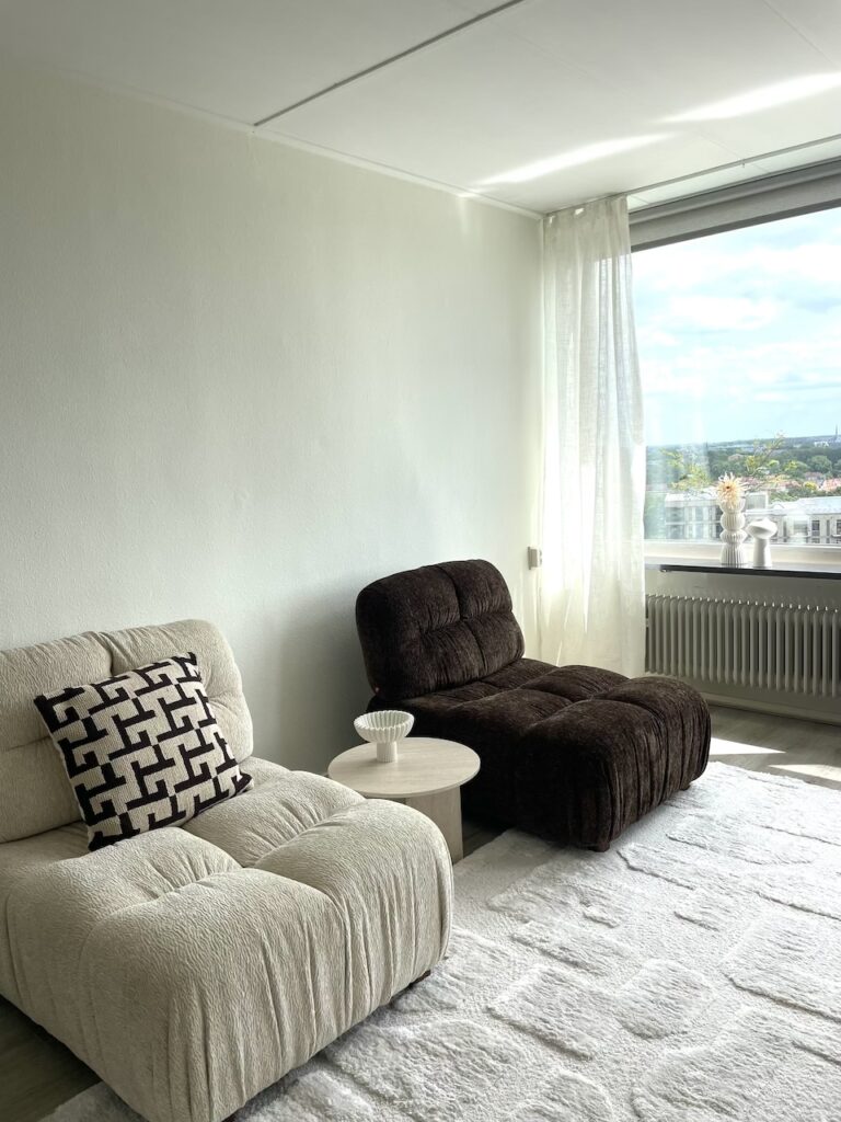 Vastgoedstyling Zwolle woonkamer met lichte fauteuil en warme bruintinten