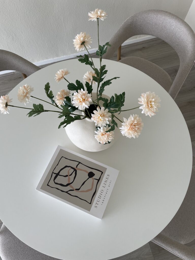 Verkoopstyling eethoek met ronde tafel en bloemen